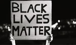 Ein Schild mit der Aufschrift "Black Lives Matter" wird hochgehalten