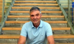 Ein Mann im hellblauen Polohemd sitzt auf einer Treppe