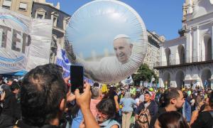 In Argentinien fotografiert ein Mann mit seinem Smartphone einen Ballon mit Foto von Papst Franziskus