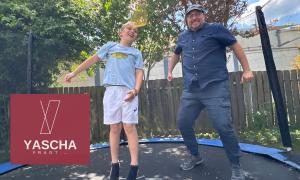 Ein Junge und ein Mann auf einem Trampolin, sie hüpfen