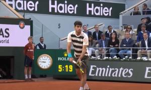 Ein Tennisspieler hat einen Schläger in der Hand, hinter ihm ein Balljunge