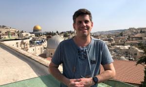 Ein Mann steht an einer Ballustrade, hinter ihm der Felsendom von Jerusalem