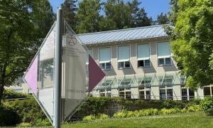 Wegweiser vor einem Haus im Grünen