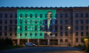 Ein Haus, an dessen Fassade ein großes Bild projiziert wird