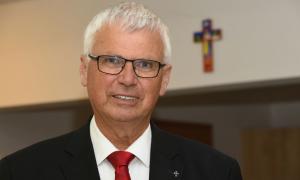 Ein Mann mit Brille, er lächelt