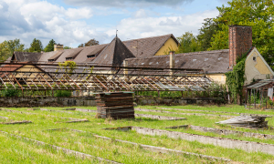 Der ehemalige SS-Kräutergarten der Zwangsarbeiter-Plantage gegenüber der KZ-Gedenkstätte Dachau. Ales Gebäude, grüne Fläche davor.
