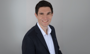 Porträt von Felix Roleder vor grauem Hintergrund.
