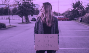 Eine Frau hält ein Schild gegen Gewalt an Frauen. Das Foto ist lila gefärbt