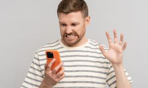 Ein Mann schaut wütend auf sein Telefon