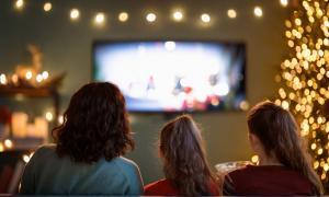 Drei Personen sitzen vor dem Fernseher