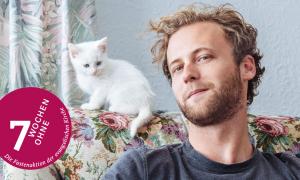 Ein Mann auf dem Sofa mit einer Katze