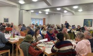 Viele Menschen an Tischen sitzend
