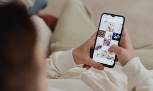 Jemand scrollt auf dem Sofa über Instagram