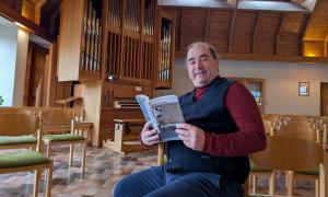 Martin Meyer mit seinem Buch "Die Orgelbauerin" in der Scheinfelder Erlöserkirche.