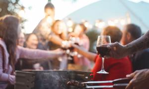 Menschen sitzen unter freiem Himmel, grillen, trinken