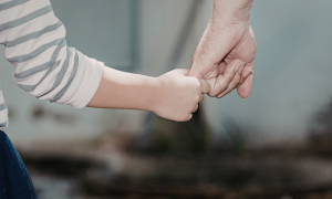 Eine Kinderhand und die Hand eines Erwachsenen