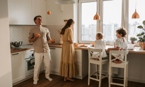 Eine Familie in der Küche, der Vater jongliert mit Orangen