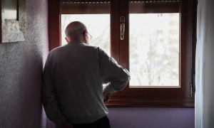 Ein Mann schaut nostalgisch aus dem Fenster