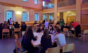 Die Kirche im pink violettem Ton während dem Galaabend. Tisch und Stühle und viele Konfirmanden