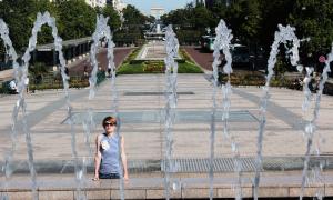 Eine Frau steht vor einem Brunnen
