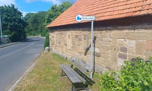 Eine Bank, an der ein Schild mit der Aufschrift "Mitfahrerbank" steht