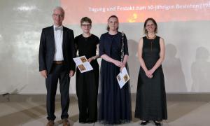 Vier Menschen in schwarz gekleidet stehen nebeneinander
