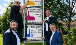 Vier Männer und drei Schilder
