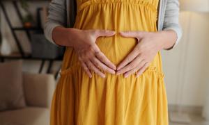 Ein Babybauch, darauf zwei Hände